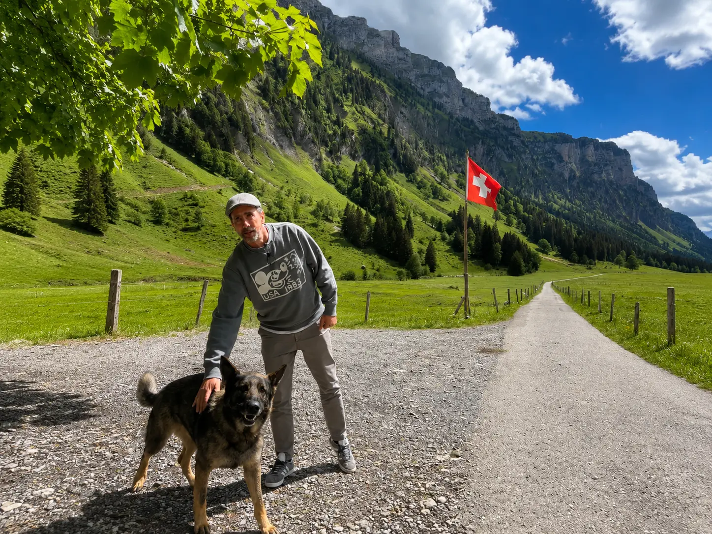 Pierre Vetsch with Alp Sigriswiler farm dog on gravel path through Justistal valley, Bernese Alps near Interlaken
