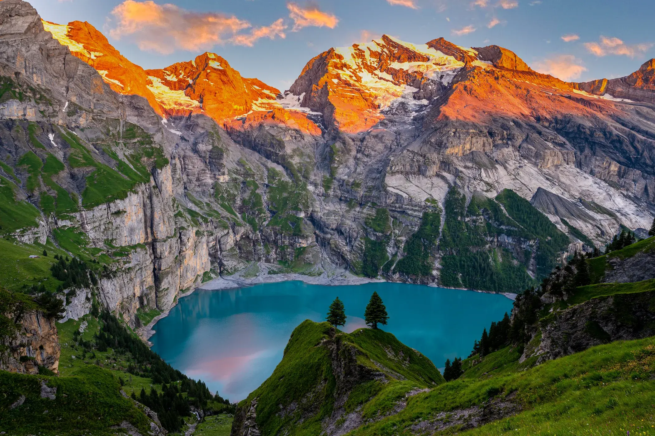 Oeschinensee at sunset with alpenglow on Blümlisalp limestone peaks above Kandersteg, Bernese Oberland Switzerland
