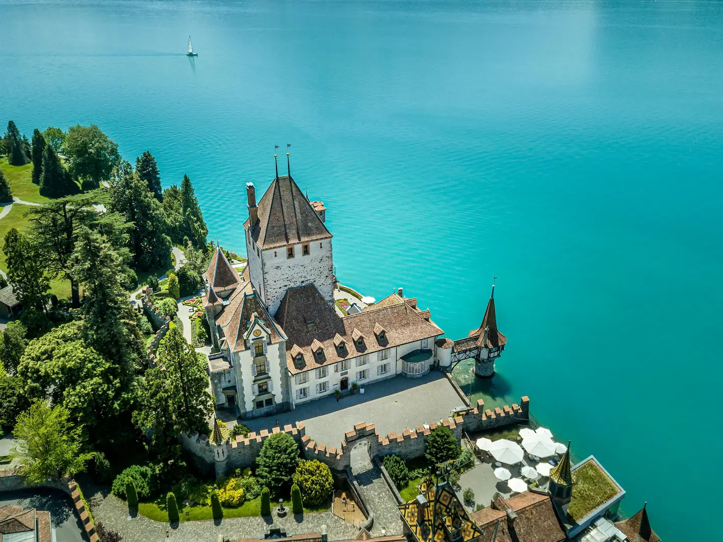 Oberhofen Castle aerial view on the turquoise shore of Lake Thun, Bernese Oberland Switzerland
