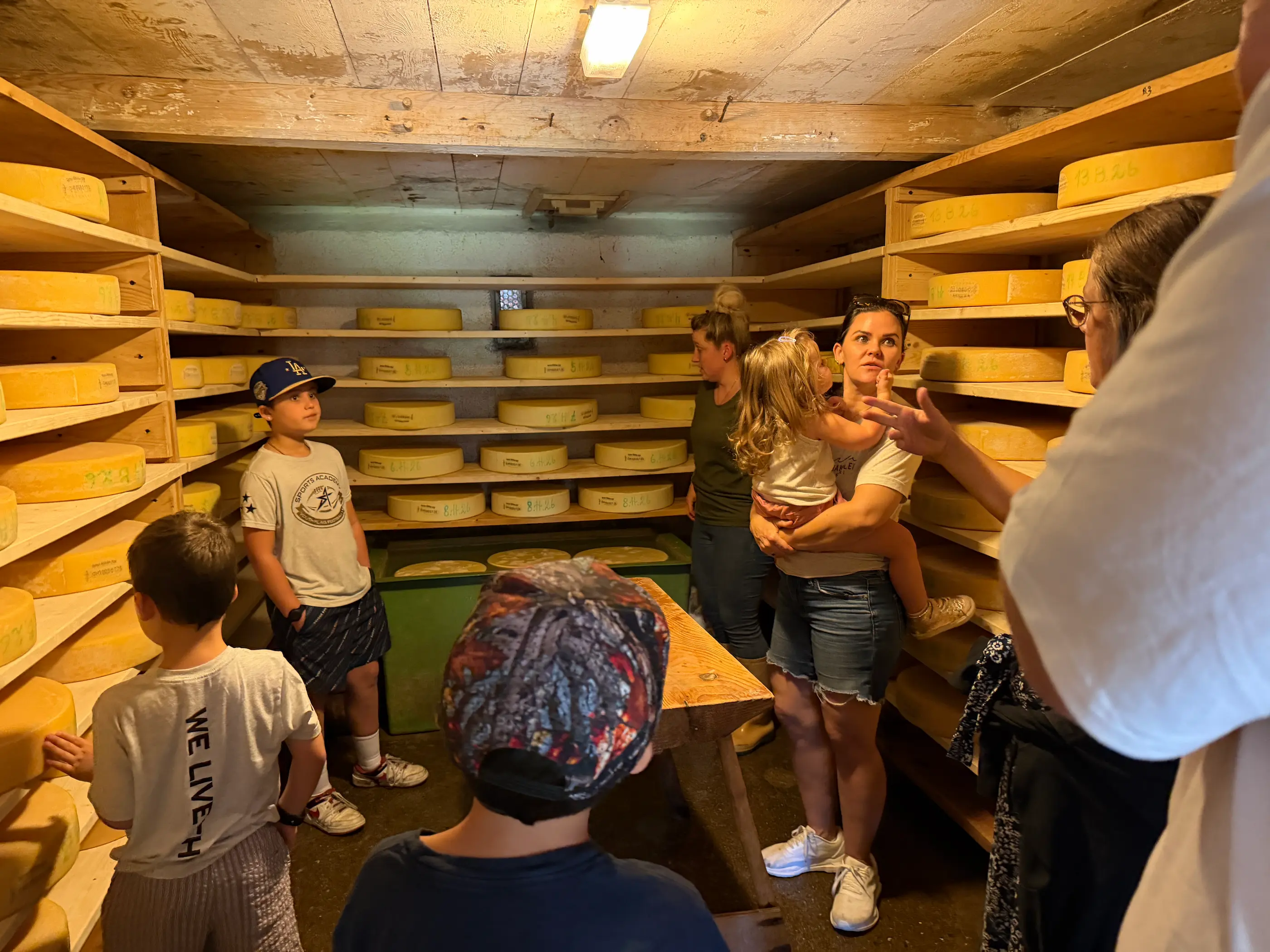 Visitors standing inside a Swiss alpine ripening cellar, a food experience you take part in rather than order