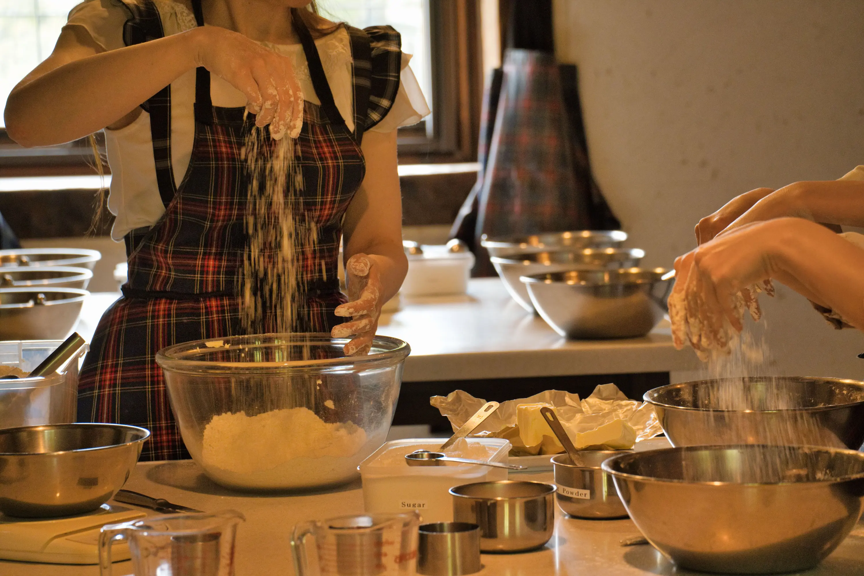 Hands sifting flour and butter in a hands-on cooking workshop, the kind of food experience you take part in